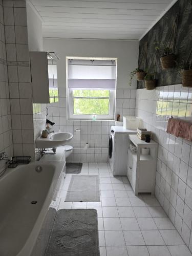 a white bathroom with a tub and a sink at Schönes Apartment in Walschleben in Walschleben