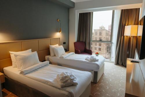 a hotel room with two beds and a window at CONGRESS Hotel in Baku