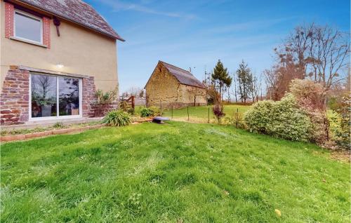 a house with a grass yard next to a building at Gorgeous Apartment In Hudimesnil in Hudimesnil