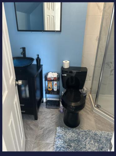 a bathroom with a black toilet and a sink at Keri APRN LLC in Ansonia