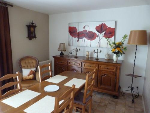 une salle à manger avec une table et une commode dans l'établissement Chez Jeannette, à Lacanche