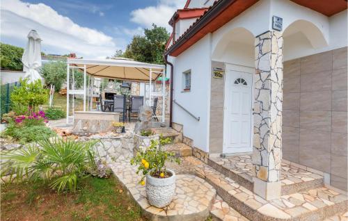 a house with a white door and a stone wall at Nice Apartment In Barbariga With Wifi in Barbariga