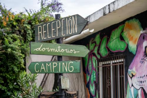 un cartello stradale di fronte a un edificio con graffiti di Ekko Hostel a Tepoztlán