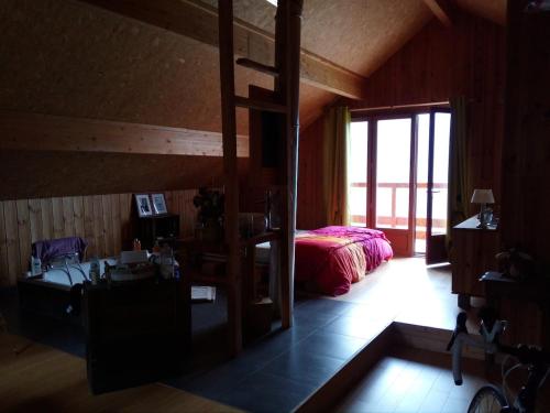 une chambre avec un lit et un bureau dans une pièce dans l'établissement chalet à Puy Sanieres avec vue sur le lac de Serre Ponçon, à Puy-Sanières