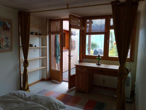 - une chambre avec un bureau et une fenêtre dans l'établissement chalet à Puy Sanieres avec vue sur le lac de Serre Ponçon, à Puy-Sanières