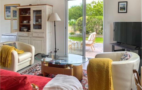 un salon avec une télévision, une table et des chaises dans l'établissement Nice Home In Lanmodez With Wifi, à Pommelin