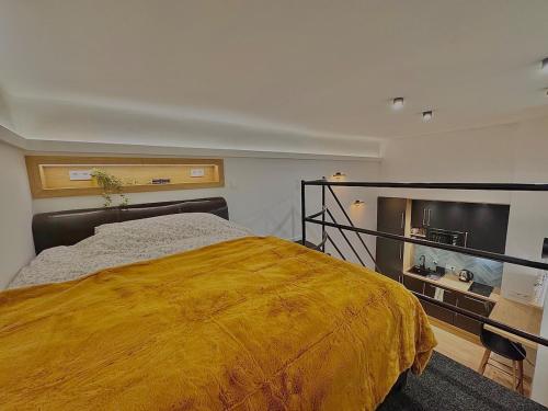 a bedroom with a bed with a yellow blanket at The Buda Garden Condo B in Budapest