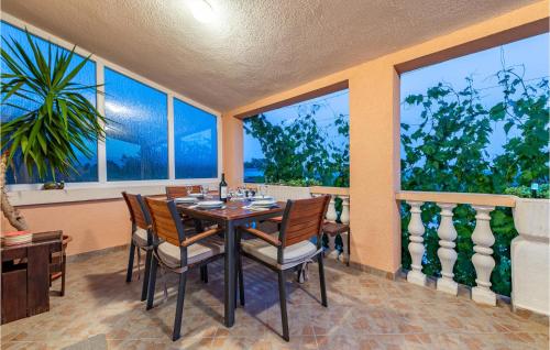 a dining room with a table and chairs and windows at Cozy Home In Slivnica in Slivnica