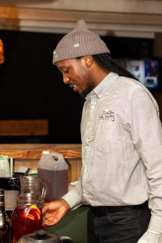 a man in a hat is looking at a jar of food at The Cacoon Tsitsikamma in Stormsriviermond