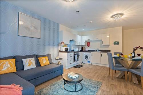 a living room with a blue couch and a kitchen at Tranquil Telford Retreat with 2 Bedrooms in Telford