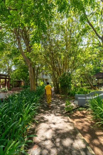 a person walking down a path in a park at Siddhalepa Ayurveda Resort - All Meals, Ayurveda Treatment and Yoga in Wadduwa