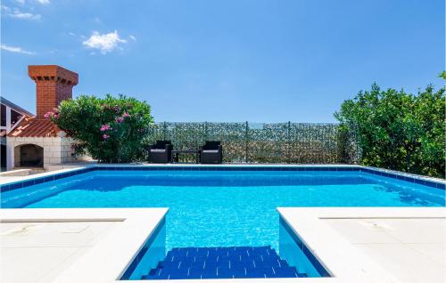 a swimming pool with blue water in a backyard at Cozy Apartment In Dubravka With Sauna in Gruda