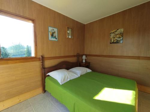 une chambre avec un lit vert et une fenêtre dans l'établissement Maison Sèrra 4 étoiles avec piscine privée, dépendance, au Vigan