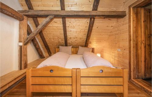 a bed in a room with wooden walls and beams at Kellerstoeckl In Strem in Strem