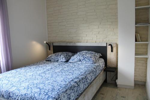a bedroom with a bed with a brick wall at Les Embruns in Neuville-lès-Dieppe