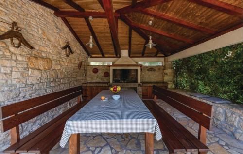 a patio with a table and a tv on a stone wall at Holiday Home Butkovici Croatia in Butkovići