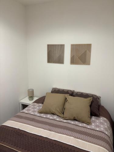 Solliès-VilleにあるLa Cigalière 2 charmant T2 avec terrasse dans villaのベッドルーム1室(壁に2枚の写真が飾られたベッド1台付)