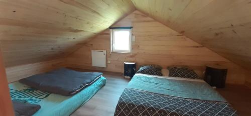 pokój z dwoma łóżkami na poddaszu w obiekcie Le chalet de Nico w mieście Château-lʼÉvêque