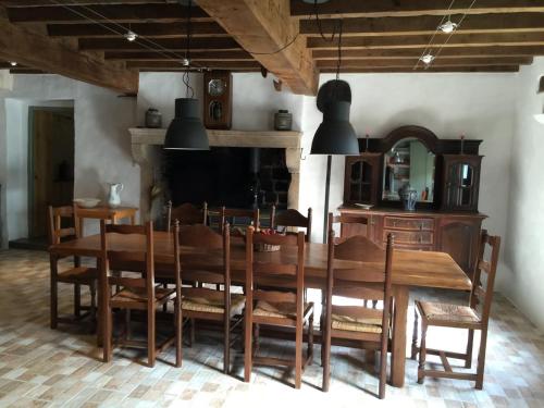 a dining room with a wooden table and chairs at Les Bouis in Saint-Hilaire