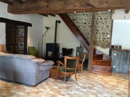 a living room with a couch and a table and chairs at Les Bouis in Saint-Hilaire