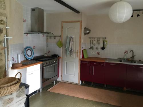 a kitchen with a sink and a stove top oven at Les Bouis in Saint-Hilaire