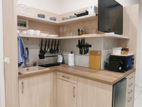 a kitchen with wooden cabinets and a sink and a microwave at Studio Zoi in Benitses