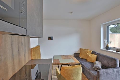 a living room with a couch and a table at Das Goldjuwel - Luxury Apartments with private Spa in Goldegg