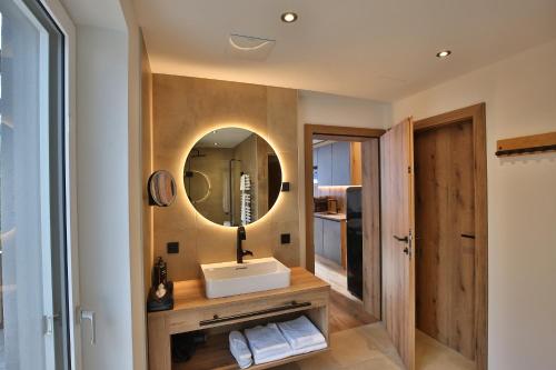 a bathroom with a sink and a mirror at Das Goldjuwel - Luxury Apartments with private Spa in Goldegg