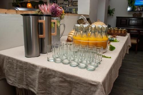 a table with wine glasses and a pitcher of orange juice at The Cacoon Tsitsikamma in Stormsriviermond