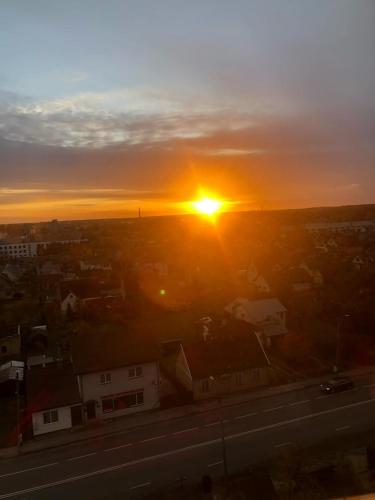 a sunset over a city with the sun setting at SKY Studio flat in Panevėžys