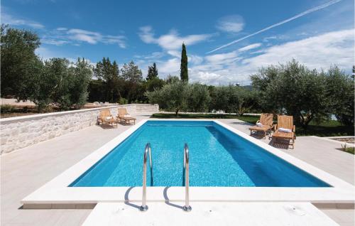 a swimming pool in a backyard with chairs at Three-Bedroom Holiday Home In Loviste in Lovište