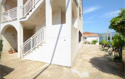 un bâtiment blanc avec des escaliers sur le côté dans l'établissement Nice Apartment In Racisce With Wifi, à Račišće