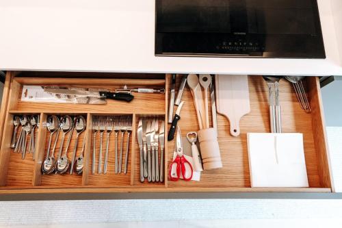 a drawer filled with cooking utensils in a cabinet at Luxe City - Modern & Spacious 2BR with Balcony View in Luxembourg