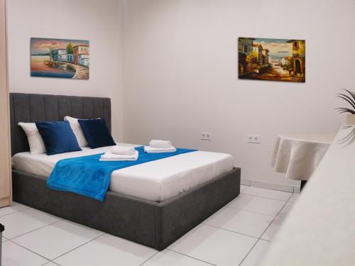 a bedroom with a bed with blue and white pillows at Studio Zoi in Benitses