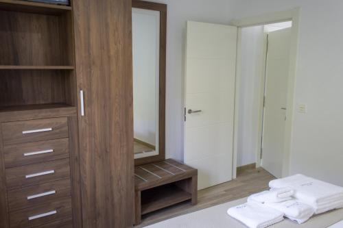 een badkamer met een houten kast en een spiegel bij Alén de Louro - Apartamento 4 Lariño in Gándara