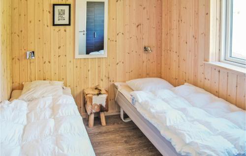 two beds in a room with wooden walls at Holiday Home Kronens Have Tranekær Vi in Hou