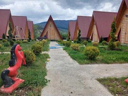 a row of wooden houses with a pathway at PROKLETIJE COTAGESEe in Plav