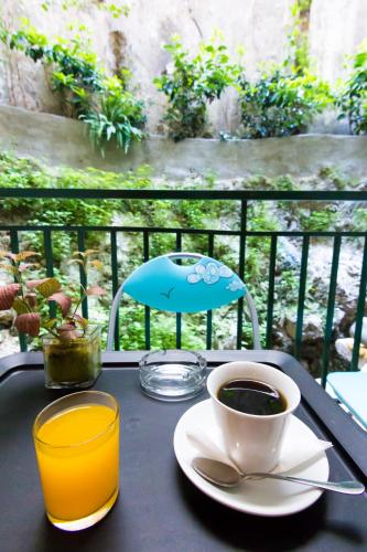 a table with a cup of coffee and a glass at Zappion Hotel in Athens
