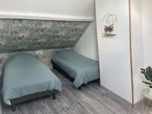 deux lits dans une petite pièce avec un miroir dans l'établissement La Bêtise, à Cambrai