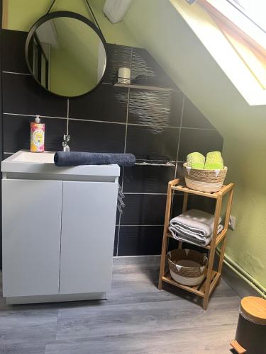 une salle de bain avec un lavabo et un miroir dans l'établissement La Bêtise, à Cambrai