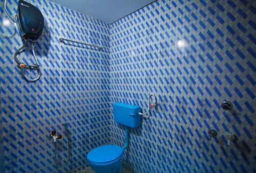 a blue tiled bathroom with a toilet and a shower at Blue Eye Coastal House, Beach House in Kaup