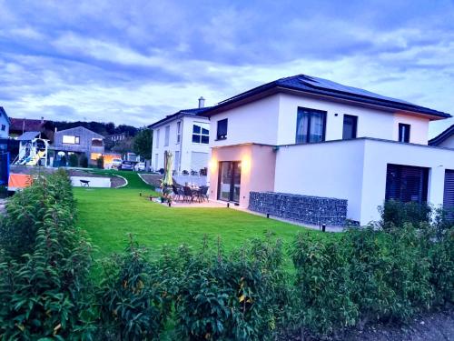una casa blanca con un patio con césped verde en Rio Home, en Büsingen