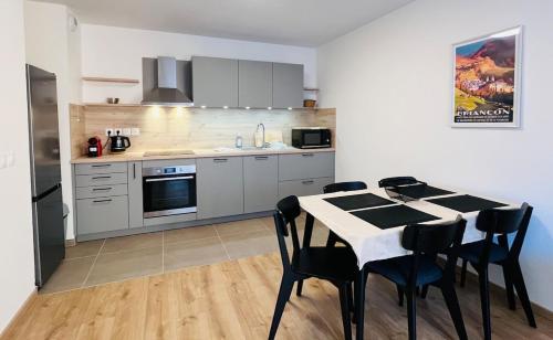 une cuisine avec une table et des chaises dans une cuisine dans l'établissement 2-Bedroom Apt by the Ski Gondola, à Briançon