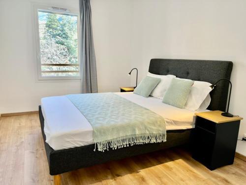 une chambre avec un grand lit avec une fenêtre dans l'établissement 2-Bedroom Apt by the Ski Gondola, à Briançon