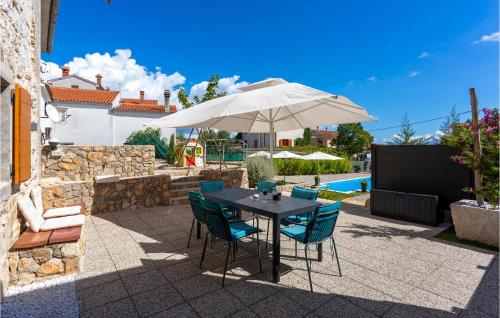 a patio with a table with chairs and an umbrella at 2 Bedroom Pet Friendly Home In Brzac in Brzac