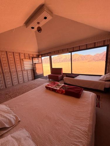 a bedroom with two beds and a view of the desert at Milky Way Wadi Rum in Wadi Rum