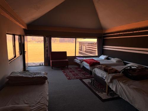a room with four beds and a chair in it at Milky Way Wadi Rum in Wadi Rum