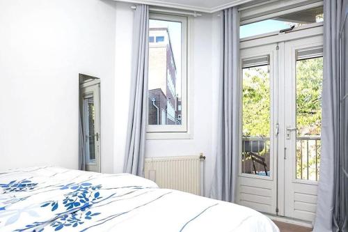 a white bedroom with a bed and a window at Beautiful quiet Apt in the center of Amsterdam in Amsterdam