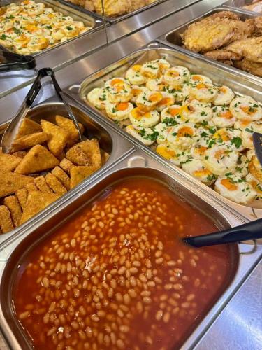a buffet with several trays of different types of food at Hotel Slovakia in Žilina