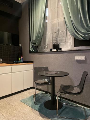 a table and chairs in a kitchen with a window at City Apartments Trier-Karl-Marx Suite 1 in Trier